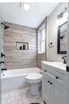 a white toilet sitting next to a bath tub in a bathroom