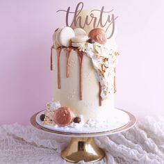 a white cake with pink and gold decorations