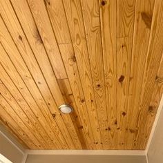 a bathroom with wood paneling on the ceiling