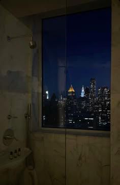 a bathroom with a view of the city at night