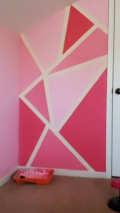 a pink and white room with a cat bed on the floor in front of it