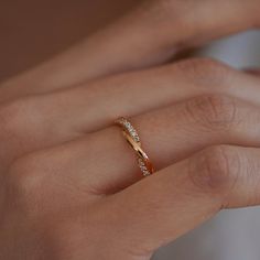 a woman's hand with a diamond ring on her left hand and the other hand holding it