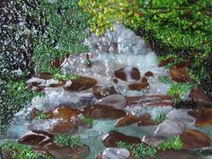 the water is running over rocks in the stream, and there are green plants growing out of it