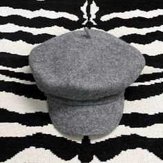 a gray hat sitting on top of a black and white rug