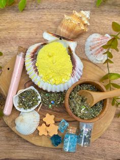 a wooden plate topped with different types of sea shells and condiments on top of it