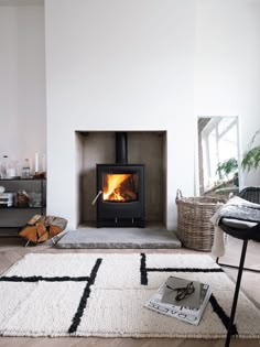 a living room with a fire place and rugs on the floor in front of it