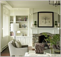 a living room filled with furniture and a fire place in front of a white fireplace