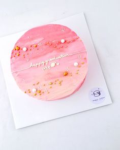 a birthday cake with pink frosting and gold sprinkles on the top