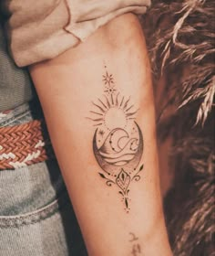 a woman's arm with a tattoo on it that has the sun and moon