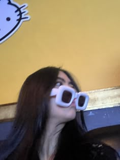 a woman wearing sunglasses looking up into the sky with hello kitty stickers on her eyes