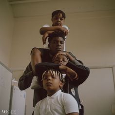 three children sitting on top of each other in front of a computer