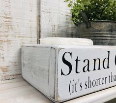 a sign that says stand out it's shorter than you think on the shelf