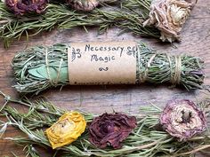 dried flowers and herbs laid out on a wooden surface with the message necessary for magic