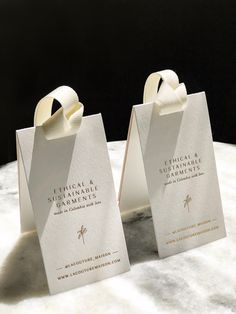 two white paper bags sitting on top of a marble table