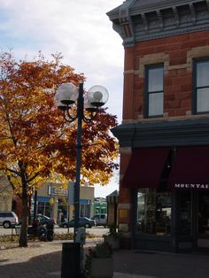 a street light sitting on the side of a road next to a tall brick building