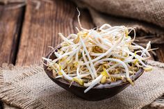 a wooden bowl filled with shredded cheese on top of a table