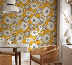 a yellow floral wallpaper in a dining room with wicker chairs and a table