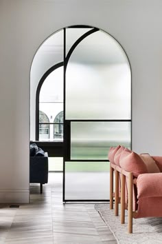 a living room filled with furniture and a large arched window