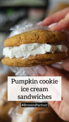 a hand holding a cookie with cream cheese on it and the words pumpkin cookie ice cream sandwiches