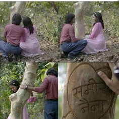 two people sitting next to each other on the ground near a tree and writing in stone