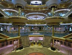 the inside of a large cruise ship with stairs and balconies on both sides