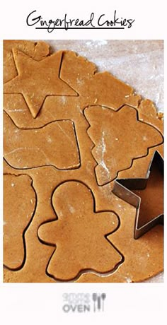 cookie cutters and star shaped cookies on top of a sheet of wax paper, ready to be baked