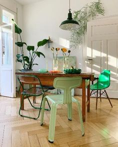 a dining room with green chairs and a wooden table