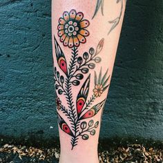 a woman's leg with tattoos on it and flowers in the middle of her legs