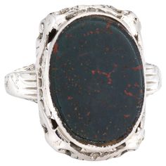 Stylish and finely detailed Art Deco bloodstone ring crafted in 14 karat white gold (circa 1920s to 1930s). Bloodstone measures 13.5mm x 10mm. The bloodstone is in very good condition and free of cracks or chips. The rich dark green teal bloodstone with sienna flecks is set flush into the mount and is perched upon a filigree gallery. The ring is great for day or evening wear. The low rise ring (6mm - 0.23 inches) sits comfortably on the finger. The ring is in good condition and was recently ligh Bloodstone Ring, Filigree Ring Gold, Detailed Art, Vintage Cocktail Ring, Gold Cocktail Ring, Gold Cocktail, Ring Crafts, Gold Filigree, Filigree Ring