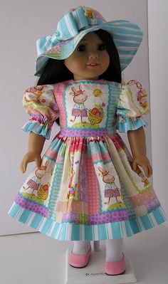 the doll is wearing a colorful dress and hat