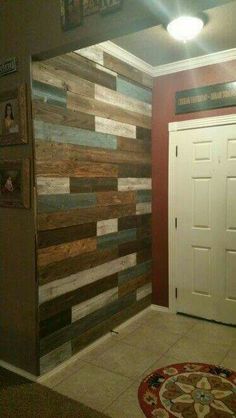 a room with wood planks on the wall and a rug in front of it