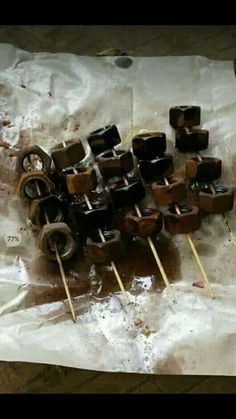 some chocolates are sitting on top of wooden skewers