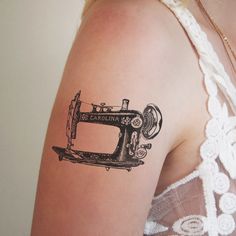 a woman with a tattoo on her arm has a sewing machine drawn on the back of her shoulder