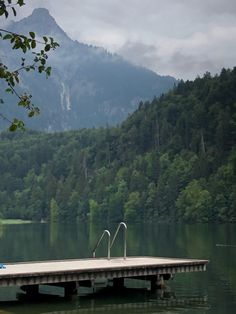 a dock in the middle of a lake with mountains in the background