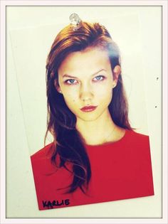 a young woman with blue eyes wearing a red shirt