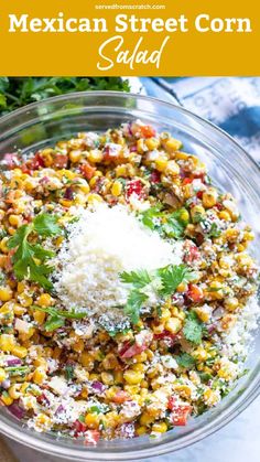 mexican street corn salad in a glass bowl with parmesan cheese and cilantro