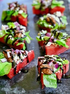 slices of watermelon are arranged on a baking sheet with greens and other toppings