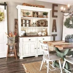 a dining room table with chairs and a hutch in the backround area