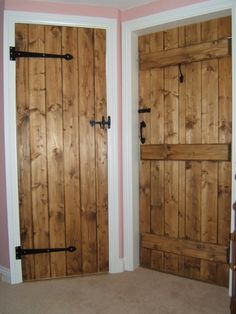 two wooden doors with black handles in a pink walled room and carpeted flooring