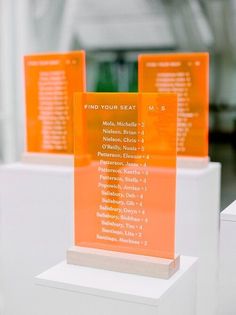 three orange and white signs on display in a room with other items behind them,