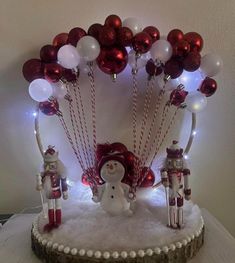 a cake decorated with red and white balloons, nutcrackers and snowmen