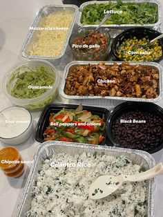 a table topped with trays of food and containers filled with different types of toppings