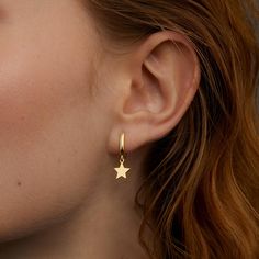 These 14k gold plated star hoop earrings are the perfect blend of elegance and simplicity. The dainty star charm adds a touch of celestial magic, making them an ideal accessory for any outfit. Crafted from hypoallergenic solid 925 sterling silver, these hoops are hypoallergenic and comfortable enough for all-day wear. Whether you're dressing up for a special occasion or adding a bit of sparkle to your everyday look, these earrings are a versatile must-have. Plus, they make a thoughtful gift for Celestial Gold Hoop Earrings Gift, Celestial Gold Dangle Hoop Earrings, Celestial Star-shaped Hoop Earrings For Everyday, Celestial Hoop Earrings With Star Charm, Gold Star-shaped Celestial Hoop Earrings, Glamour Jewelry, Dainty Hoop Earrings, Celestial Jewelry, Gold Hoops