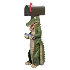 a mailbox mounted to the side of a statue of a crocodile holding a cell phone