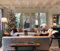 a living room filled with furniture and a christmas tree in the middle of the room