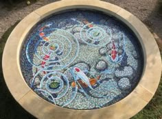 an artisticly designed fountain in the shape of a circle with fish and waves on it