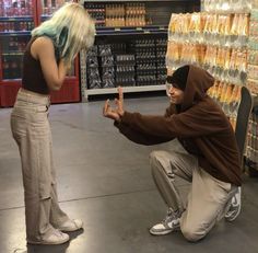 a man kneeling down next to a woman in a store