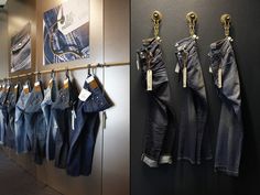 there are many jeans hanging on the wall