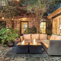 an outdoor living area with couches and fire pit