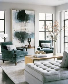 a living room filled with lots of furniture next to large window covered in white curtains